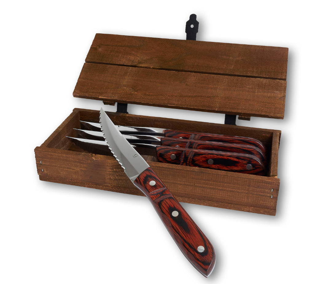 The Gense: Old Farmer Micarta Steak Knife set includes four serrated steak knives with wooden handles, housed in an open wooden box. One stainless steel knife is displayed in front, highlighting its dishwasher-safe durability.