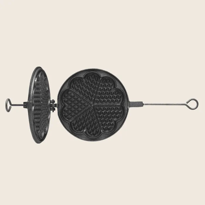 The Skeppshult: Waffle Iron 8.25 / 21 cm, a vintage handcrafted waffle maker with a heart-shaped pattern, is open to show its handle and latch mechanism against a plain background.