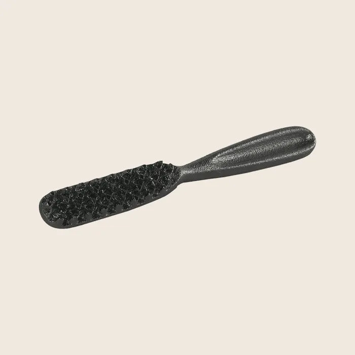 The Skeppshult Fish Scaler is a textured black brush with a handle, ideal for preparing seafood, isolated on a plain background.