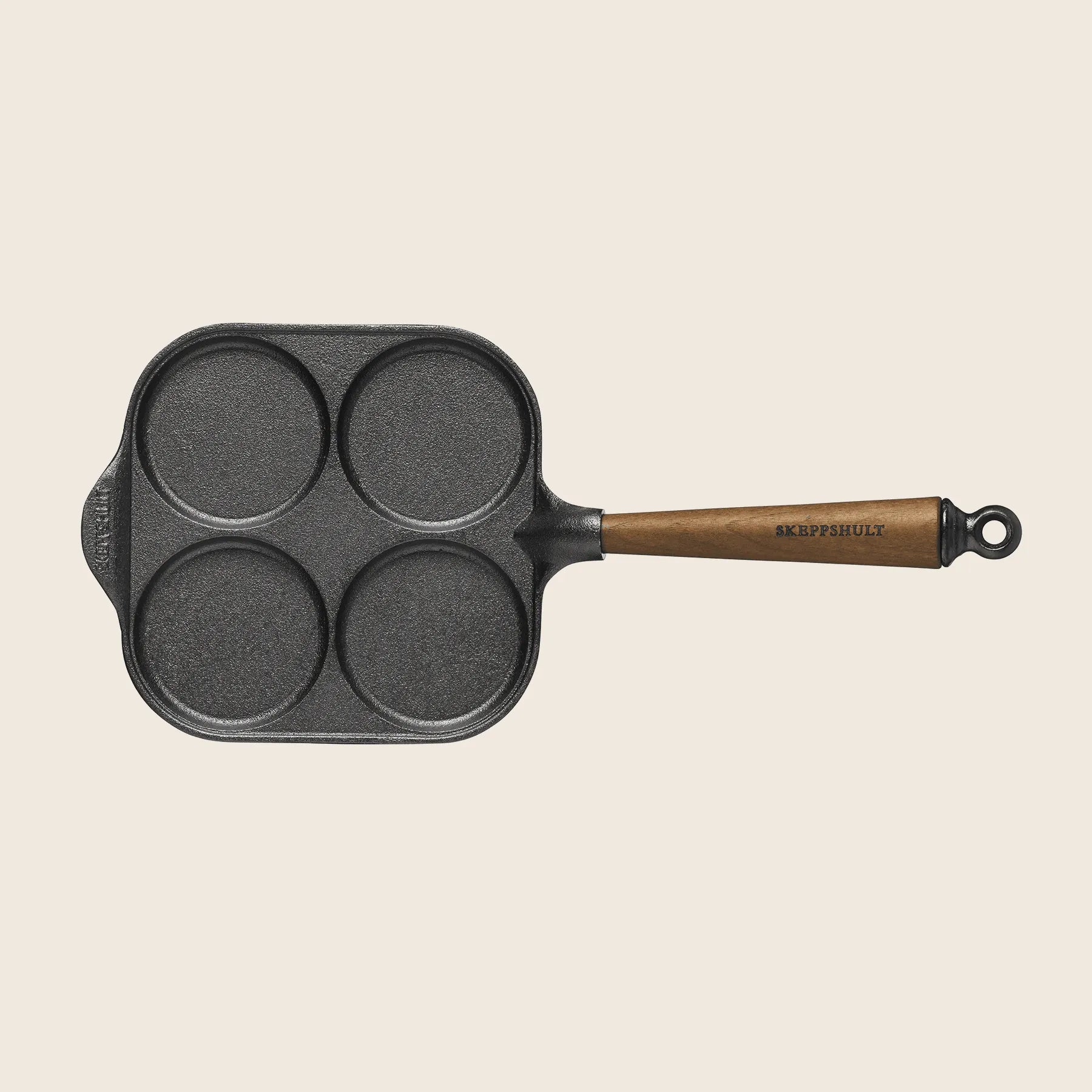 The Skeppshult Egg Pan, measuring 8 (20 cm), features a black cast iron design with four circular compartments and a walnut handle for culinary precision.