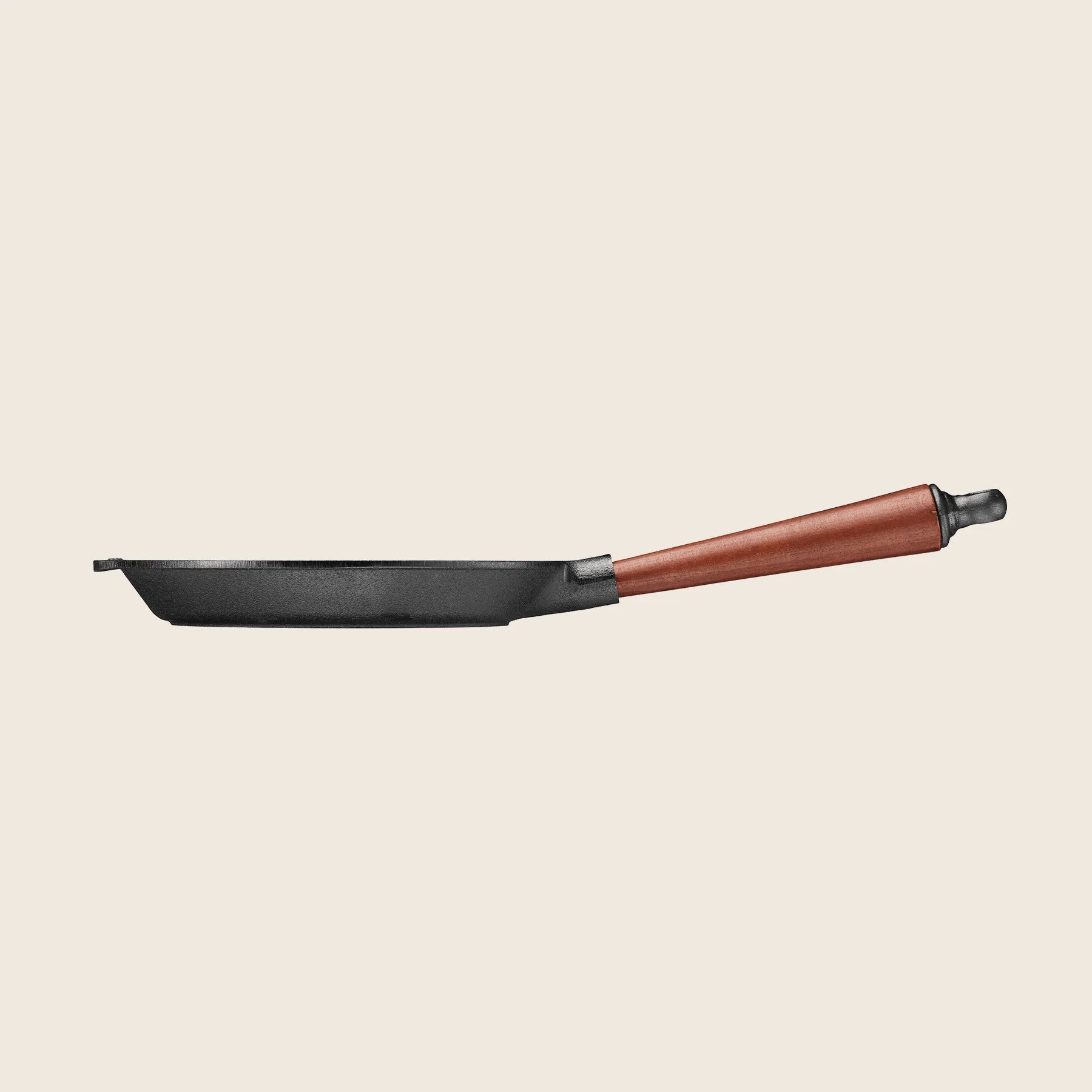 The Skeppshult Skillet, 8.6 with a walnut handle, is showcased side profile on a plain background. Designed for superior heat conduction, this sleek black frying pan features a non-stick finish to enhance your cooking experience.