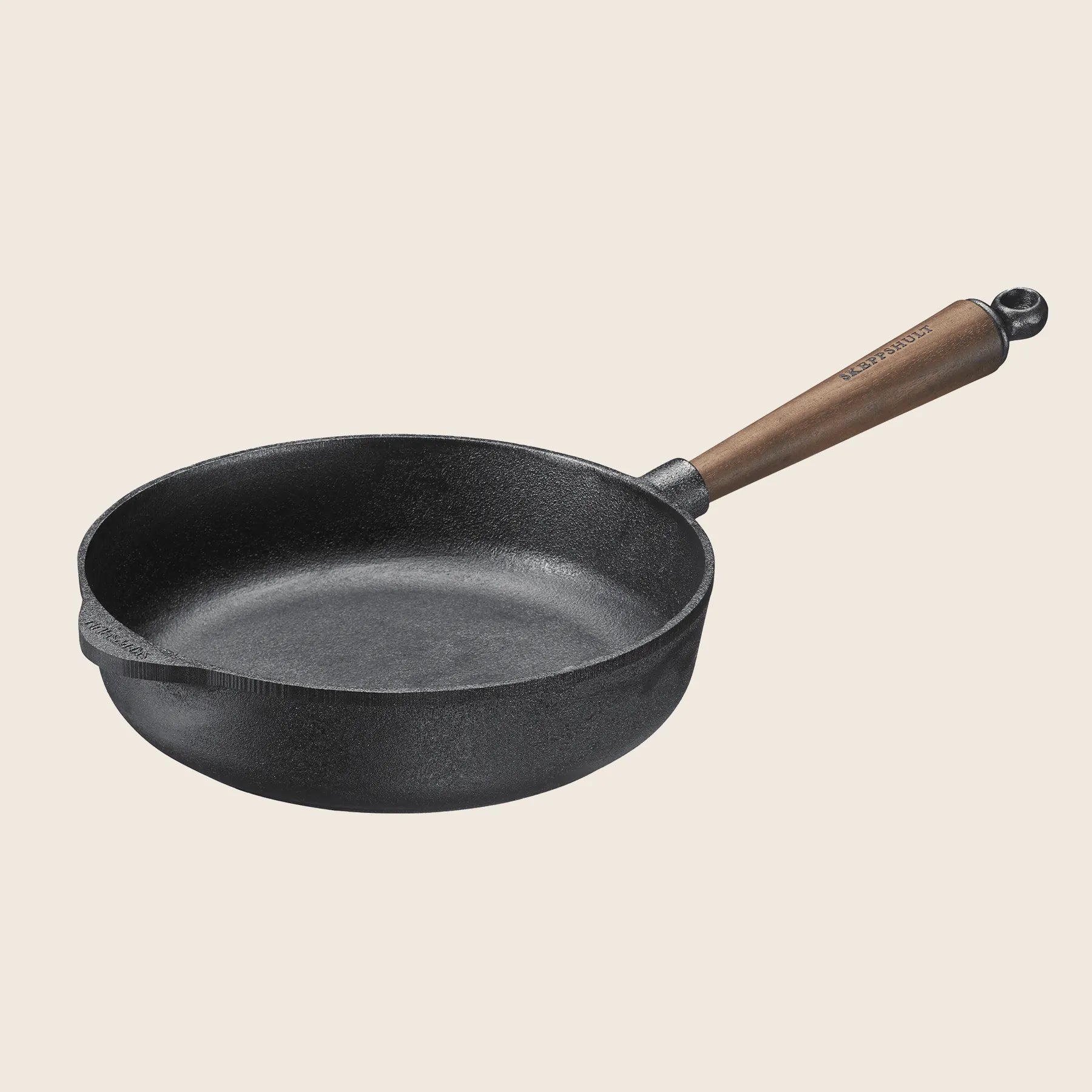 The Skeppshult Deep Skillet, handcrafted in Sweden, features a 9.75 black cast iron frying pan with a rich brown walnut handle. Shown against a light background, it promises enduring quality and a non-stick surface for exceptional cooking experiences.