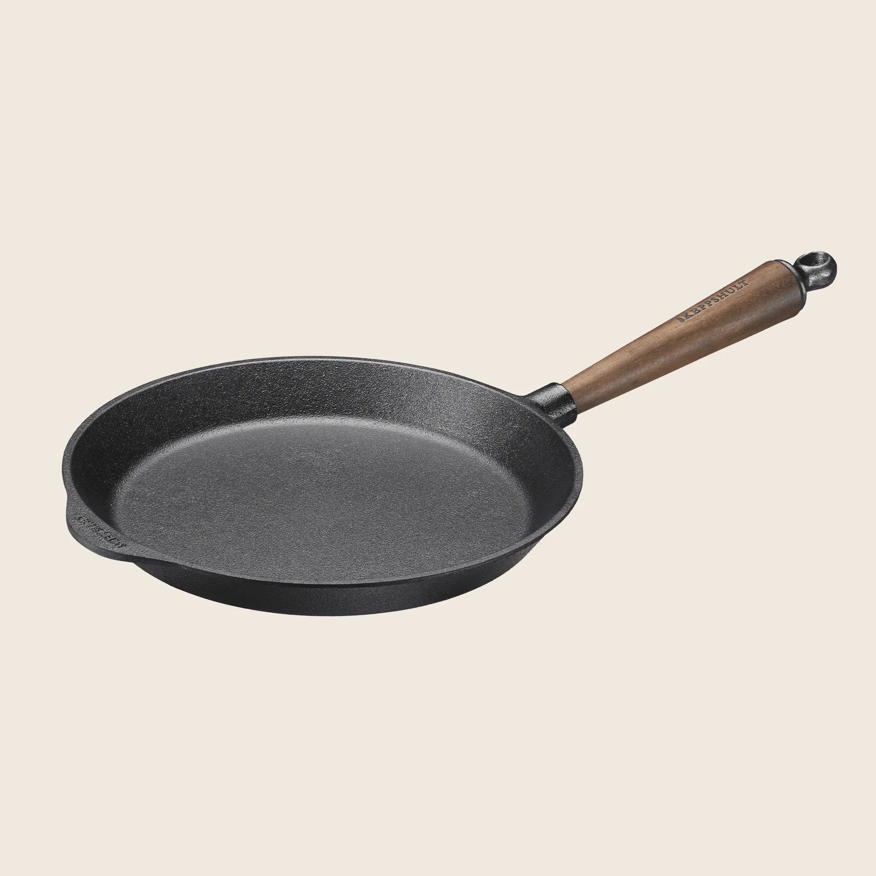 The Skeppshult Skillet With Walnut Handle 10 / 26 cm rests on a plain background, combining style with functionality.