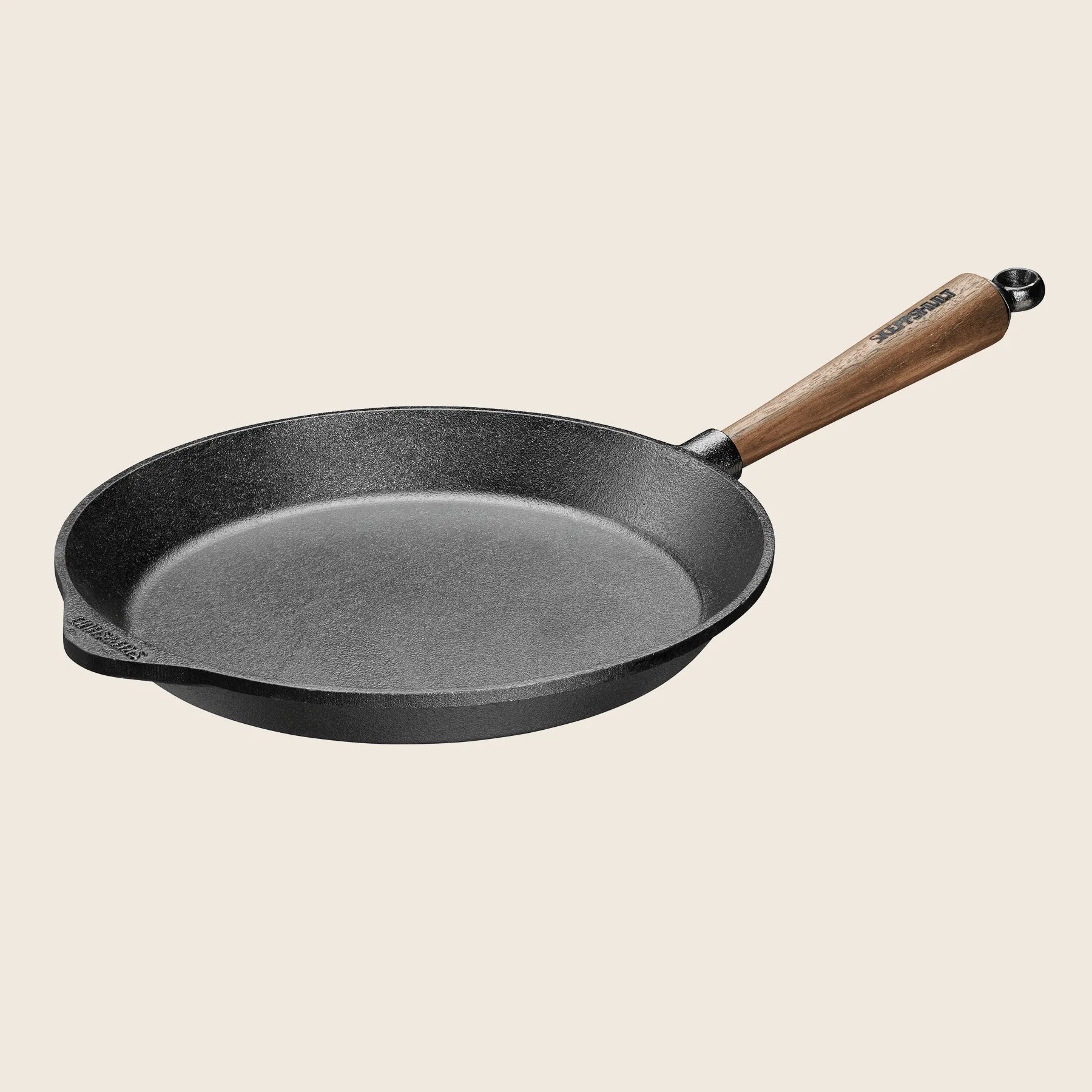 A Skeppshult 11 black cast iron skillet with a walnut handle offers excellent heat conduction against a light background.