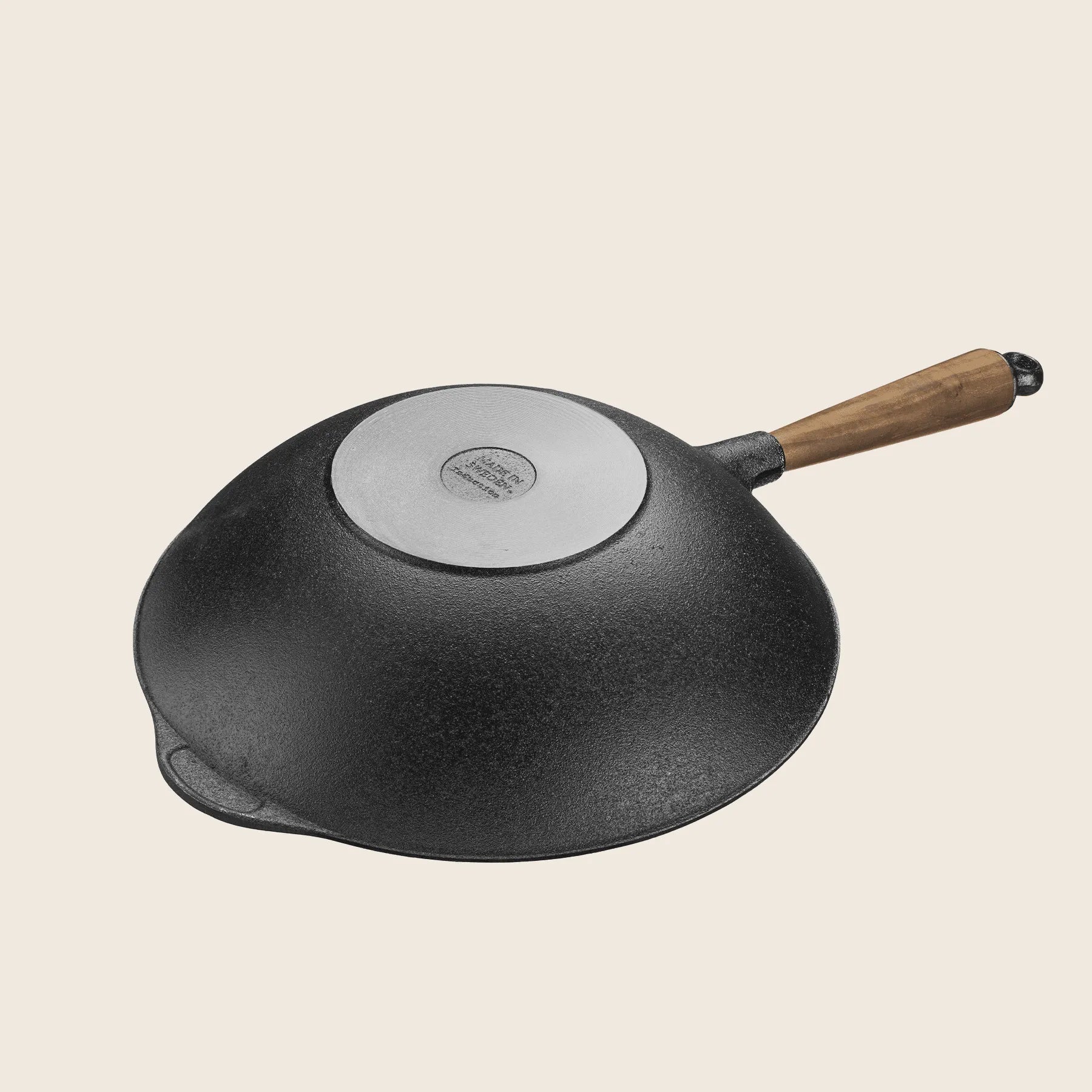 The Skeppshult 12.2 cast iron wok, featuring a walnut handle and shown upside down on a light background, offers a natural non-stick surface.