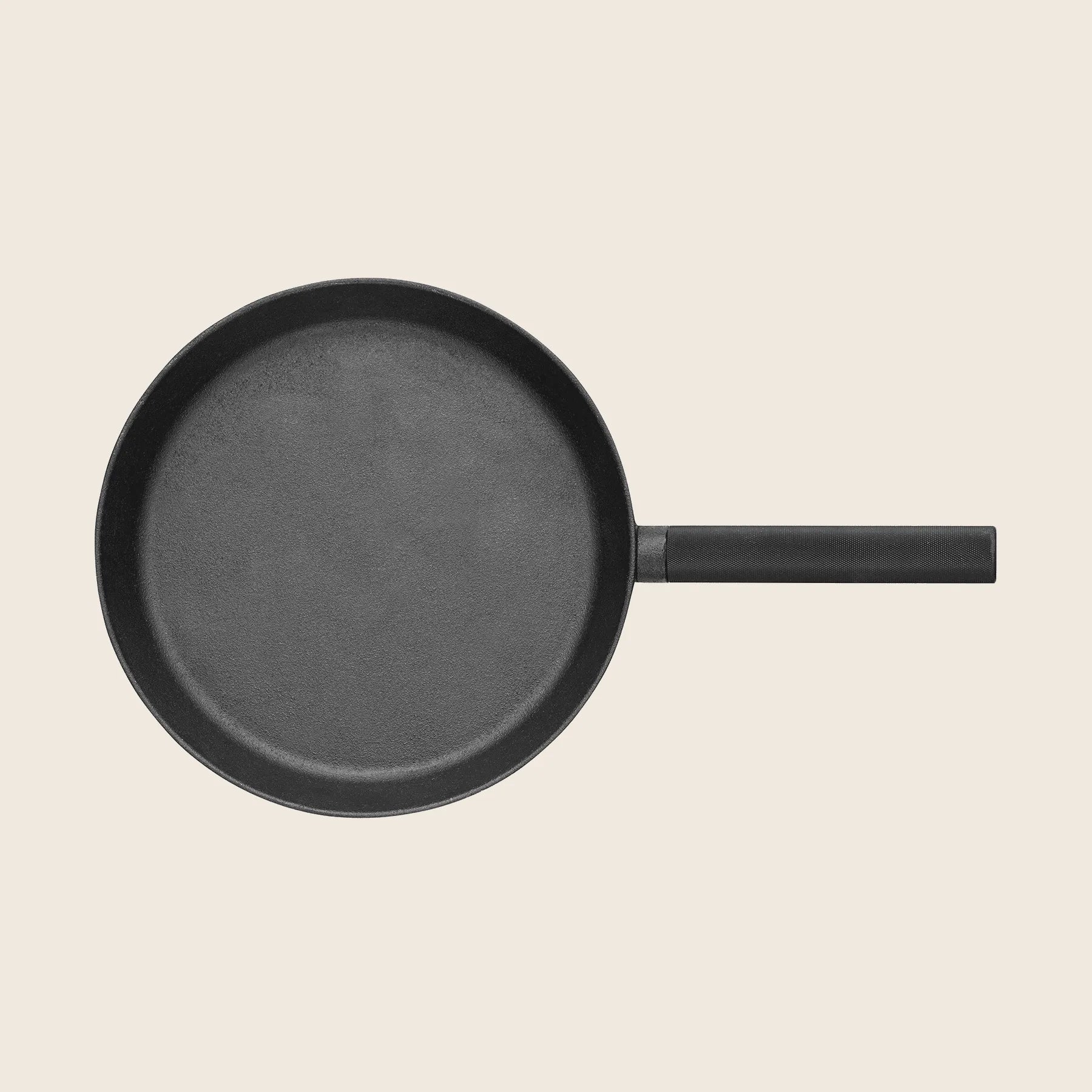 An 11 Skeppshult Skillet with a long handle is centered against a light beige background, highlighting its non-stick surface.