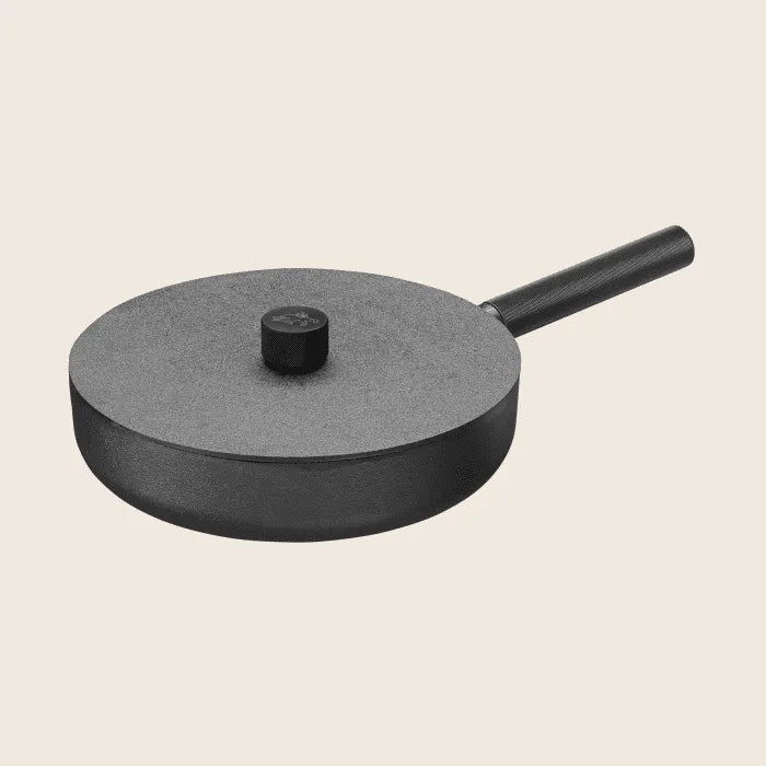 The Skeppshult Deep Skillet, measuring 11 inches (28 cm), is elegantly displayed on a plain, light background. Its sleek black design features a non-stick surface, matching lid, and handle.