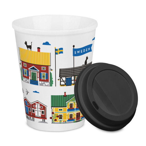 The Sweden To Go Mug is a white porcelain travel mug with a black lid, featuring colorful illustrations of Swedish houses, a flag, and a cat—an ideal souvenir for your trip.