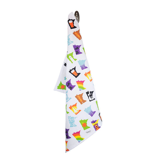 The Tea Towel: Minnesota Months, designed with a cat theme and made from soft cotton, is displayed hanging from a hook against a white background.