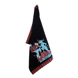 The Tea Towel: Paul & Babe Cheers! Tea Towel by Adam Turman features a black design with a red plaid border, showcasing an illustration of Paul Bunyan, Babe the Blue Ox, and two people standing on barrels.