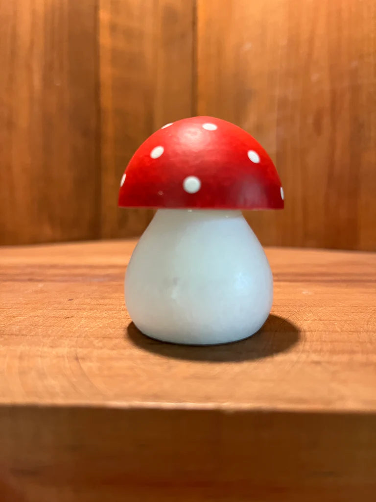 The Figurine: Handcrafted Swedish Toadstool Figurine, with a charming hand-painted red cap adorned with white spots, rests elegantly on a wooden surface.