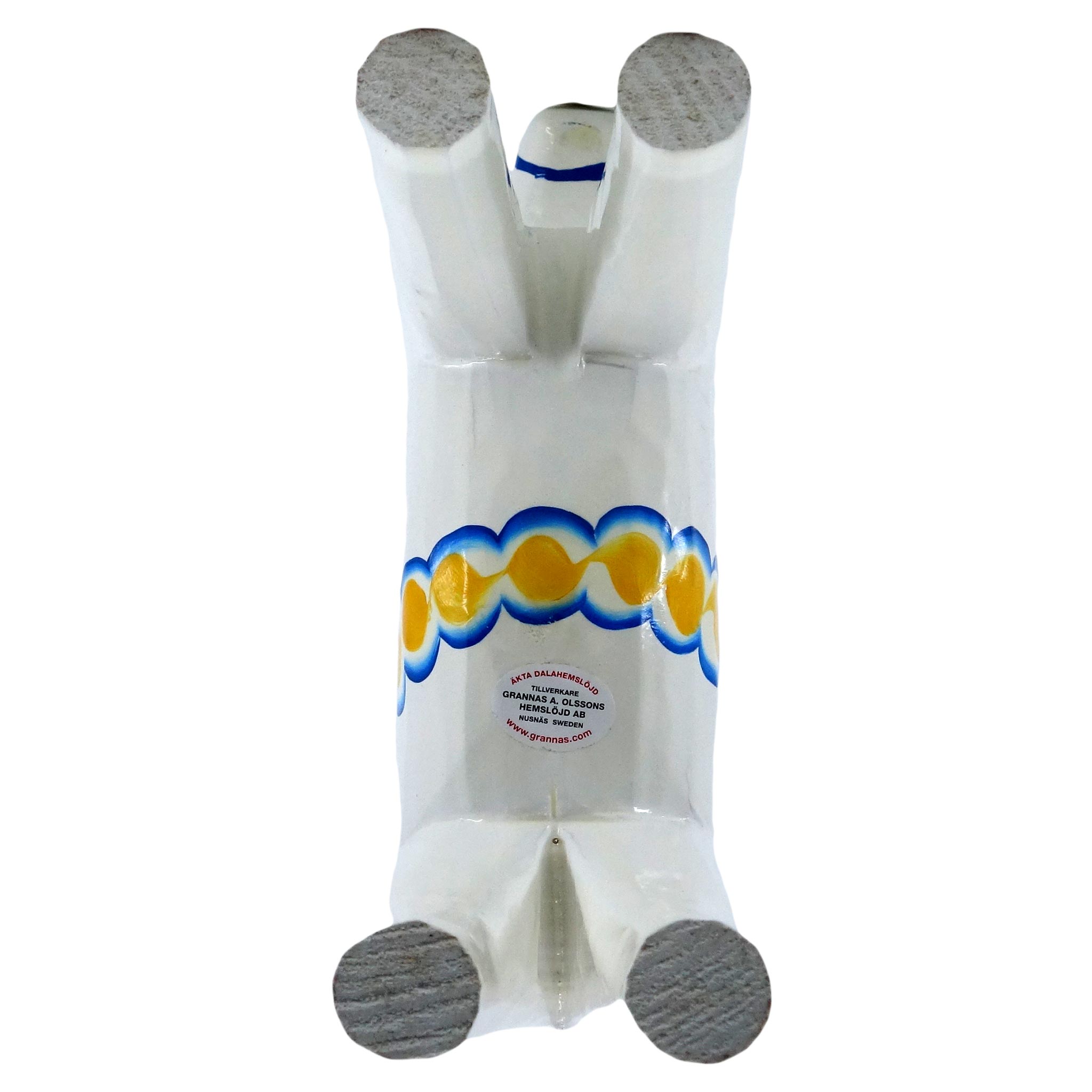 A white ceramic Dala Horse from the Swedish Flag Series lies on its back, featuring blue and yellow kurbits patterns around its middle.