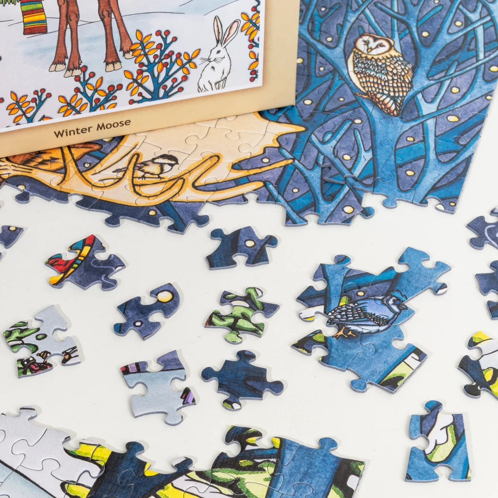 Jigsaw puzzle pieces with images of owls, a rabbit, and colorful patterns are scattered on a white surface.