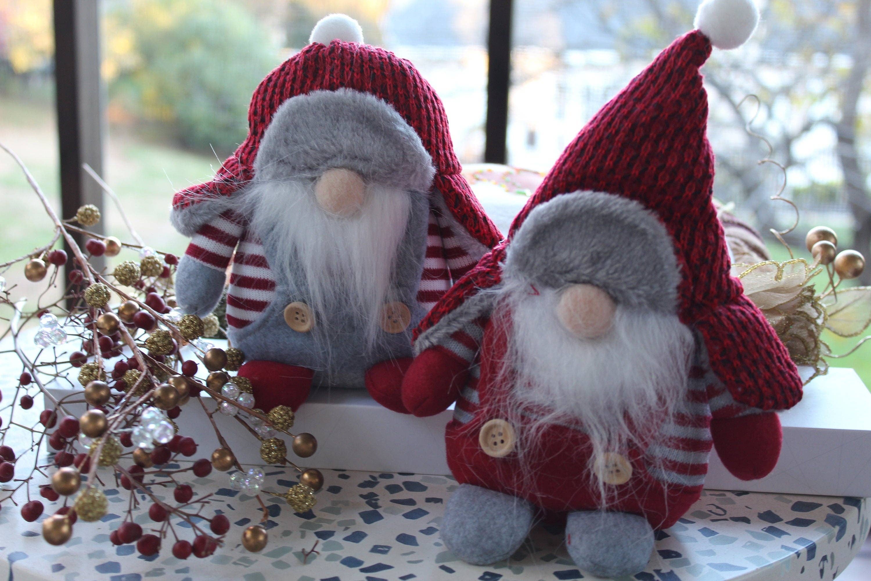 Aldrich and Bernard, the Winter Gnomes from our Christmas Gnomes collection, with their iconic red hats and striped shirts, sit cheerfully on a decorated table, capturing the enchanting charm of Scandinavian household spirits.