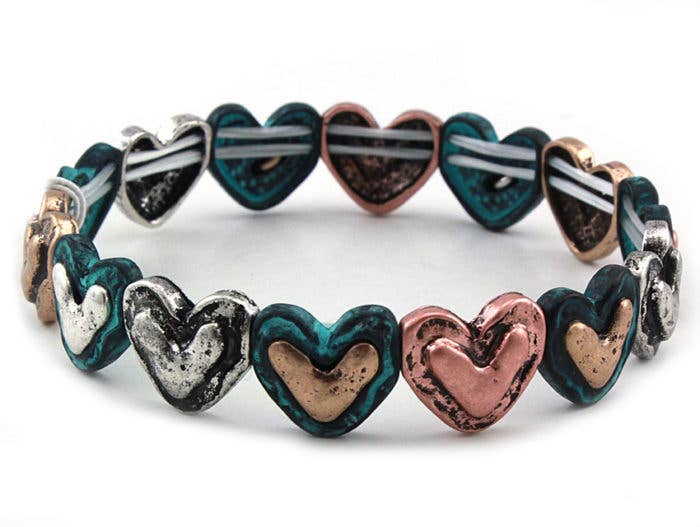 The Bracelet Small Hearts Stretch Bracelet - Multi-patina features heart-shaped beads in metallic teal, silver, bronze, and copper. This lead- and nickel-free bracelet offers a stylish, comfortable option for everyday wear.