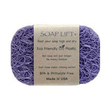 Purple soap saver made of tangled bioplastic fibers with a beige label showing text about material features.