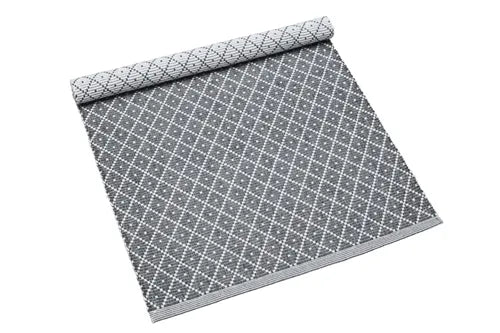 Gray woven placemat made with recycled textiles, featuring a white diamond pattern design on a dark grey background.