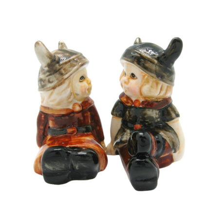 The Viking Couple Vintage Salt & Pepper Shakers, 3" tall, feature two ceramic children in Viking helmets facing each other—an adorable earthy-toned set for adding Scandinavian charm to your kitchen decor.