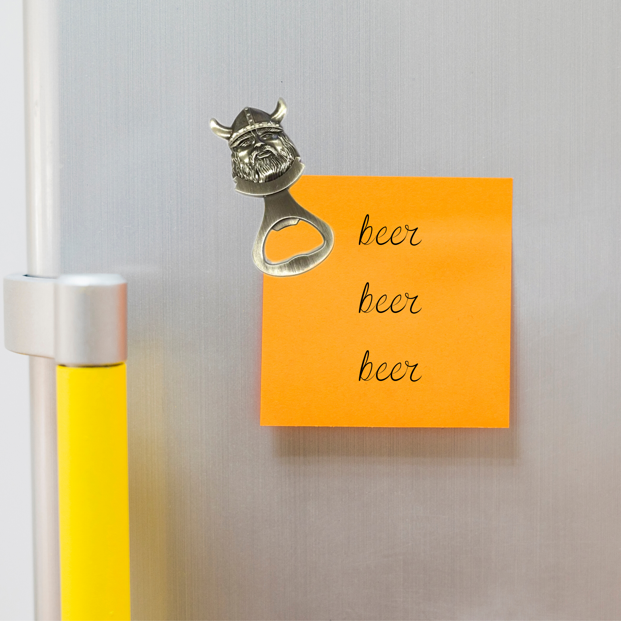 A Norwegian Viking Metal Bottle Opener Magnet sticks to the fridge, just beside an orange note with beer beer beer written on it.