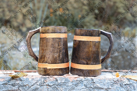 Two Coffee Mug: Wooden Viking Tankard – Vibrant Orange Finish (16–18 oz Capacity), handcrafted with decorative orange bands, sit side by side outdoors, showcasing rustic Viking charm against a blurred natural backdrop.