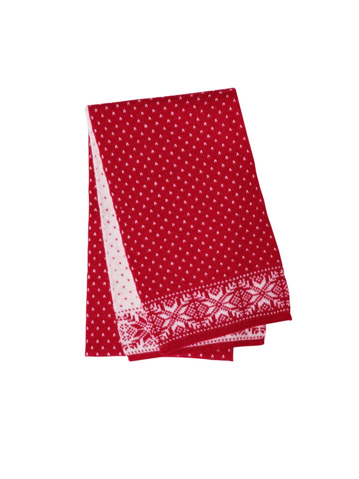 The Norlender scarf in red and white, featuring snowflake and polka dot patterns, is folded neatly.