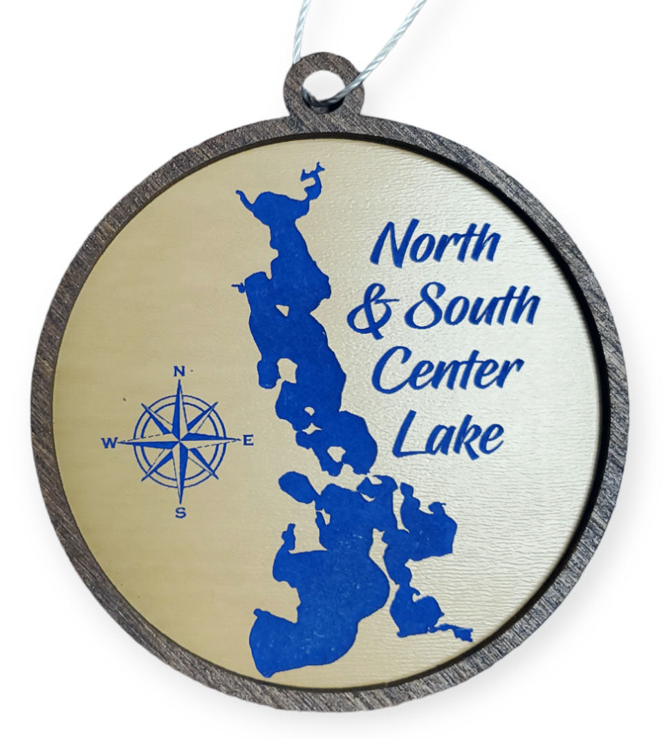 Round wooden ornament featuring an etched map labeled "NO & SO Center Lake" with a compass rose on the left, designed to resemble quilting fabric.