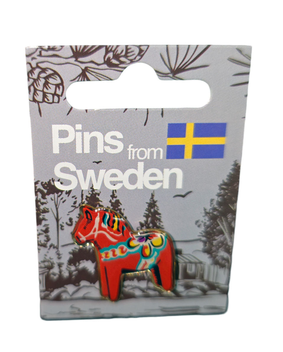 A vibrant metal lapel pin featuring a Red Dala Horse is attached to a card labeled "Pin: Dala Horse" from Sweden, adorned with the Swedish flag and showcasing intricate kurbits designs.