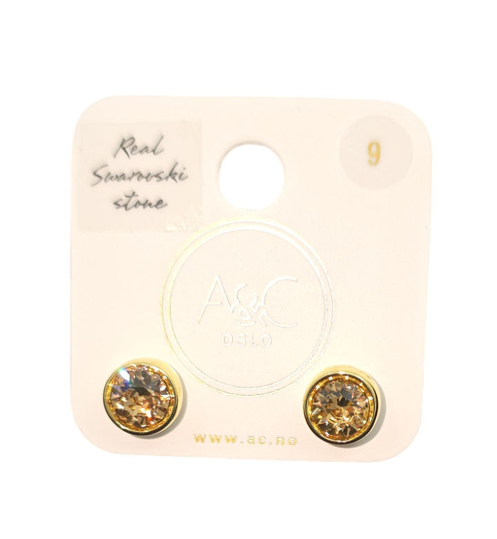 A pair of Colorado Topaz earrings by A&C Norway, adorned with Swarovski crystals, exquisitely showcased on a white card featuring A&C Oslo branding, capturing the essence of Norwegian nature.