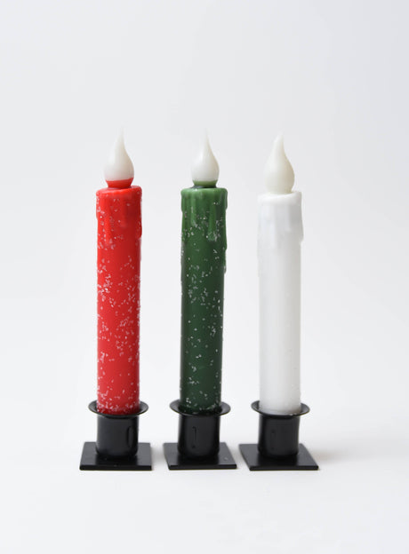 Three Candle: Diamond Dusted Christmas LED Timer Taper Candles in red, green, and white stand upright in black holders. Each features wax drips and sparkling diamond dust for a festive holiday look.