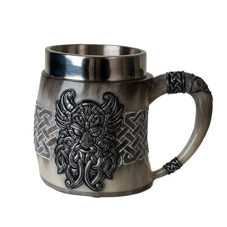 The Coffee Mug: Viking Odin's Horn Drinking Mug features a metal interior and a raised bearded face with intricate knot patterns, making it an ideal novelty Viking gift for fans of Norse designs.