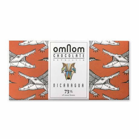 A chocolate bar with an orange wrapper covered in illustrated crocodile heads and a geometric animal logo; labeled Candy: OmNom Nicaragua 73% Dark Chocolate Made from Nicaraguan Cocoa Beans, 60g.