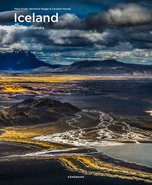 Cover of the book "Iceland (Spectacular Places)," featuring a breathtaking scene with dramatic clouds, majestic mountains, and a flowing river. Authors Petra Ender, Bernhard Mogge, and Christian Nowak beautifully capture the enigmatic beauty of Icelandic fjords and glaciers in this captivating cover.