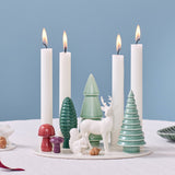 Handmade porcelain advent candle holder with four white candles, decorated with ceramic trees, a deer, a squirrel, and mushrooms.