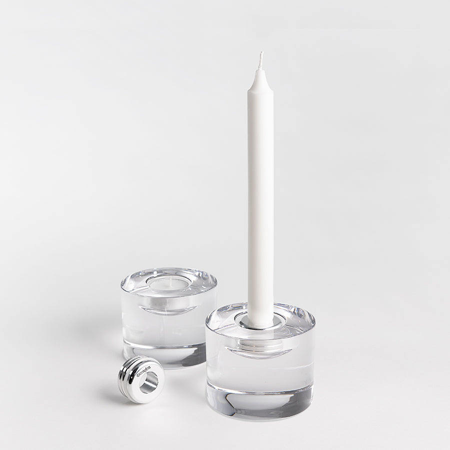 An Orrefors Lightswitch Adapter - Candle Holder Converter holds a white taper candle, with another identical converter beside it on a pristine white background.