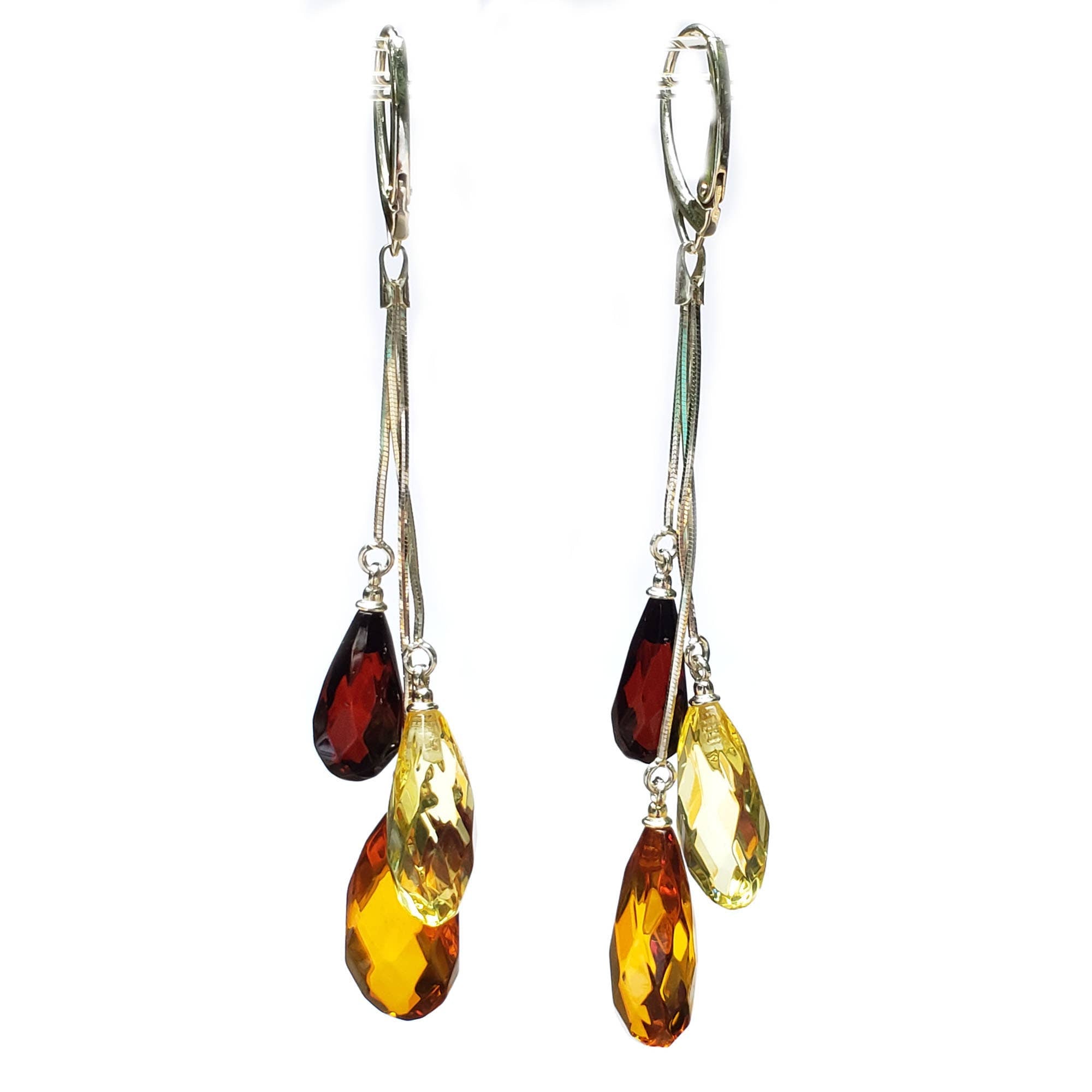 The Faceted Multicolor Amber Earrings on Hooks feature three teardrop-shaped amber stones in red, yellow, and amber tones, each dangling elegantly from fine chains for a graceful look.