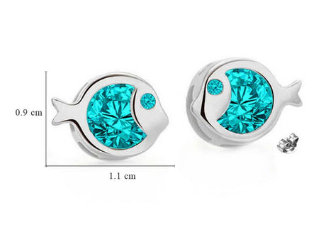A pair of fish-shaped silver studs featuring princess-cut aquamarine Swarovski® crystals, each measuring 0.9 x 1.1 cm. One earring is shown next to a size reference. Product: Earrings: Fish Shaped Swarovski® Crystal Silver Studs.