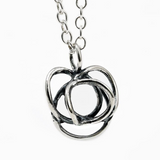 The Flor Alida Floral Necklace features a 5/8" abstract sterling silver pendant on an 18" chain, inspired by Scandinavian design, shown on a white background.