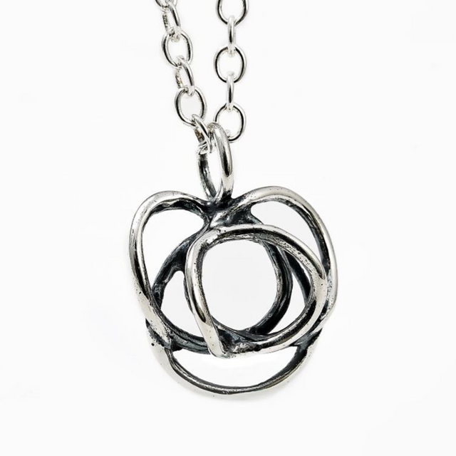 The Flor Alida Floral Necklace features a 5/8" abstract sterling silver pendant on an 18" chain, inspired by Scandinavian design, shown on a white background.