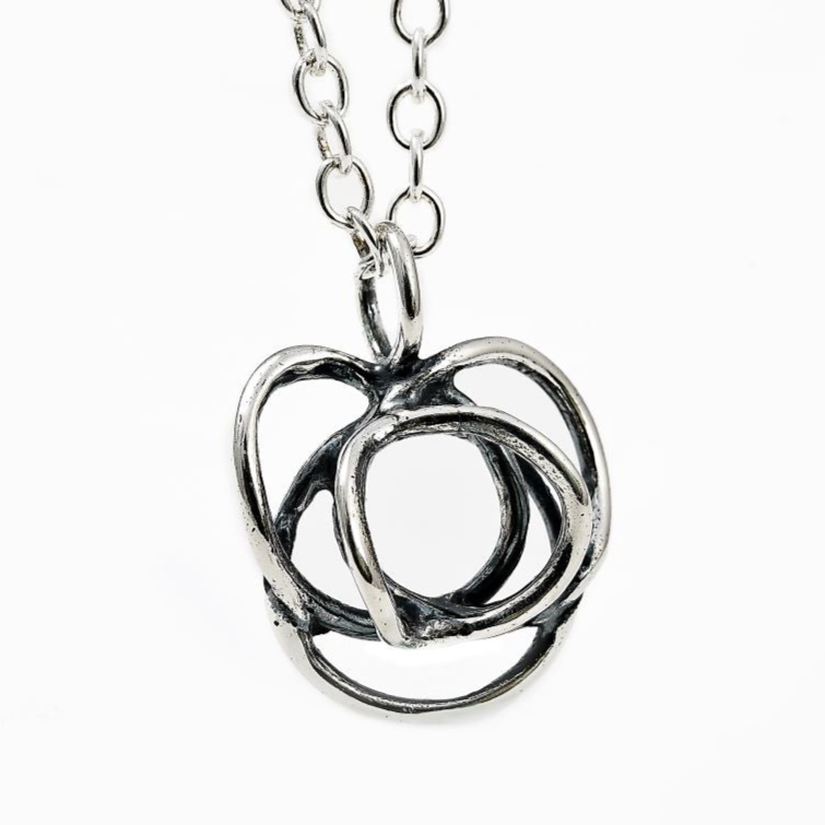 The Flor Alida Floral Necklace features a 5/8" abstract sterling silver pendant on an 18" chain, inspired by Scandinavian design, shown on a white background.