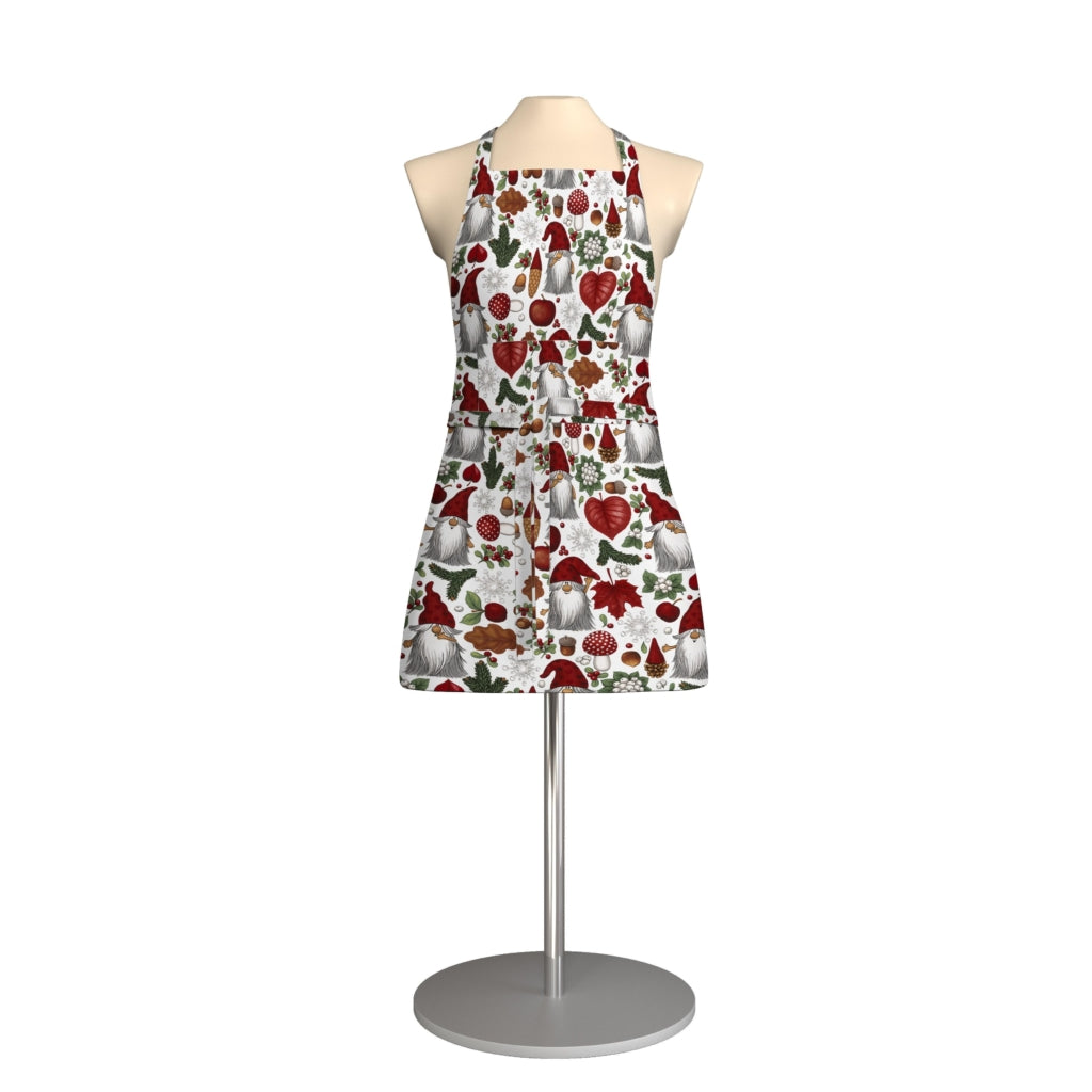 A mannequin displays the Tomteskogen Apron with Pocket, featuring a red and green botanical fruit pattern of pomegranates and leaves—a festive Scandinavian touch for your holiday kitchen—on a circular stand.