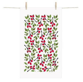 The Rose Hip Terry cotton towel by Anneko Design Sweden, featuring a classic Swedish pattern of green leaves, red berries, and black branches, hangs on a clothesline with two clothespins.