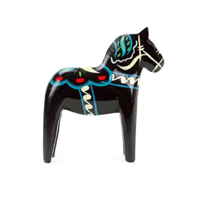 A black, hand-painted wooden Dala horse with colorful patterns stands upright on a white background.