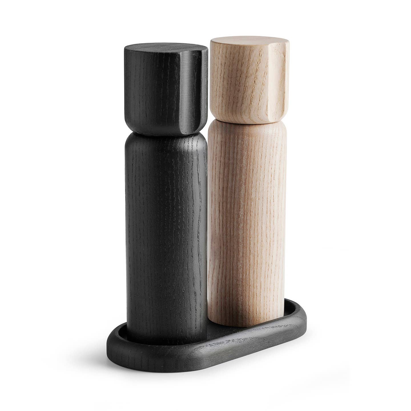 The Shakers: Salt and Pepper Grinder Set from Sweden features two wooden cylindrical grinders, one black and one light wood, standing on a matching oval base—an elegant Scandinavian-inspired design.