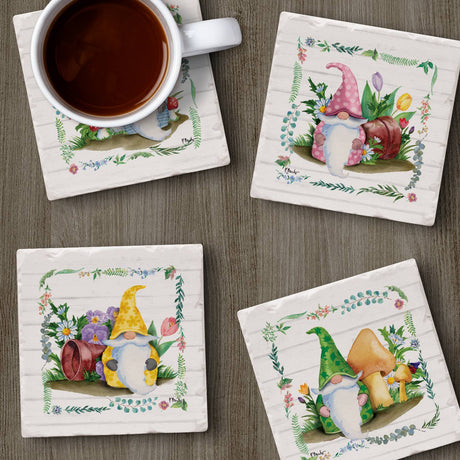 The Coaster: Spring Gnomes Tumbled Tile Coaster Set – 4 Pack, with floral and gnome designs, sits on a wooden surface for a rustic touch; one coaster holds a coffee cup.