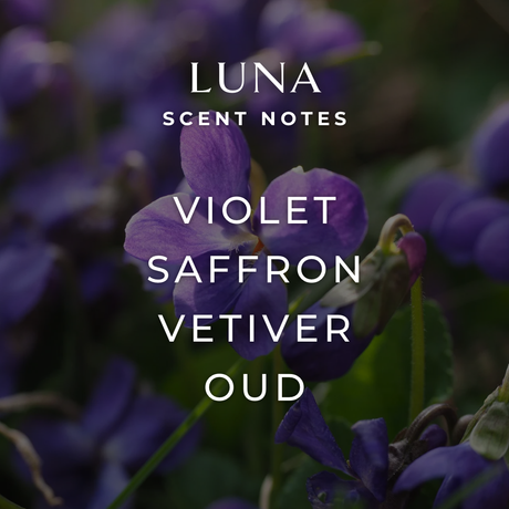 Close-up of purple violet flowers with text overlay: Luna Scent Notes—Violet, Saffron, Vetiver, Oud. Elevate your space with the Luna Candle: 8oz jar, 2 wicks, 45+ hour burn by Fjord & Fable. Artisanal soy wax for an elegant home fragrance.