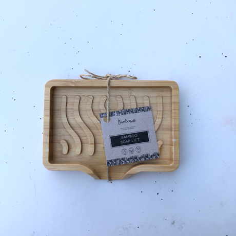 Rectangular bamboo soap holder with wave-shaped grooves, tied with twine, and labeled with a kraft paper tag.