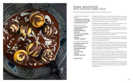 A plate of zebra Æbleskiver topped with chocolate and vanilla sauces sits beside a fork, inspired by the book Aebleskiver by Pim Pauline Overgaard—a fresh take on traditional Danish pancakes.