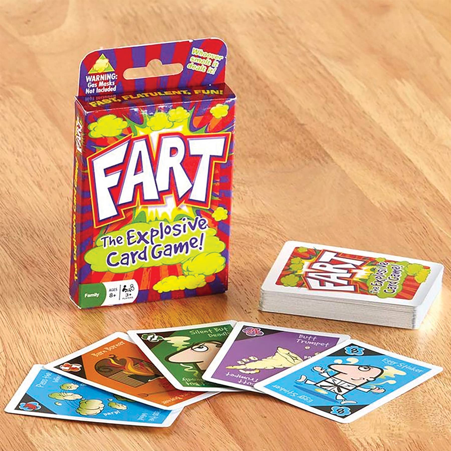 Displayed on a wooden table is "Game: Fart Card Game," offering an explosive and flatulent adventure. A collection of colorful cards featuring cartoon characters are spread out in front of the box, inviting players to embark on this whimsically hilarious card game experience.