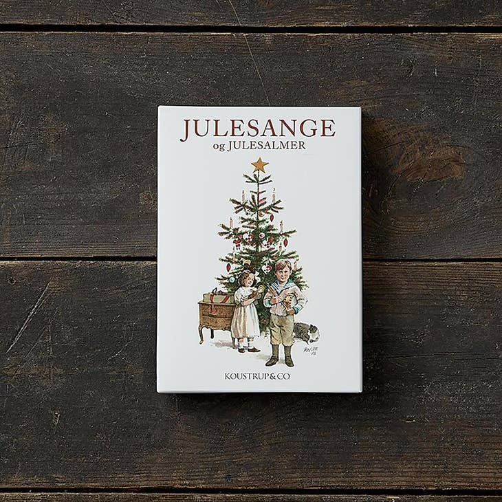 A Card Pack titled *Julesange og Julesalmer*, featuring an illustration of children and a Christmas tree on the cover, lying on a wooden surface. Ideal for pairing with eco-friendly envelopes for your festive Christmas cards collection.