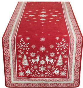 Red jacquard table runner featuring white reindeer, snowflakes, trees, and geometric borders displayed on a rectangular table.